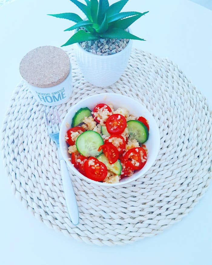 Bright vegan salad with quinoa, cucumbers, and tomatoes in a cozy home setting.